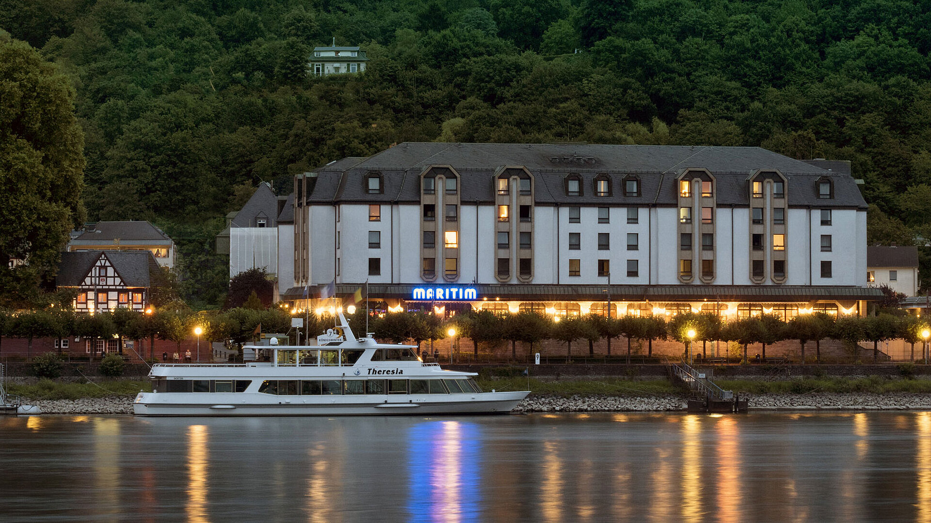 Exterior view at night Maritim Hotel Königswinter at night with atmospheric lighting and a view of the Rhine.