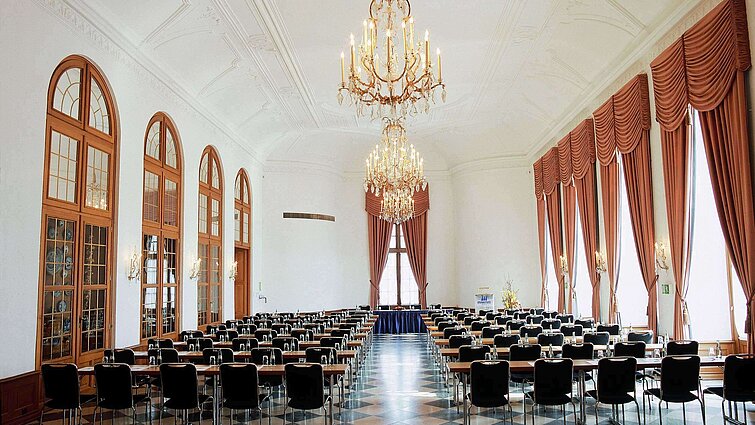 Salón de eventos elegante en Maritim Hotel Fulda con lámparas, ventanales altos y asientos sofisticados.