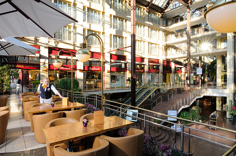 Café Heumarkt at Maritim Hotel Cologne with seating and service staff in a stylish atmosphere.