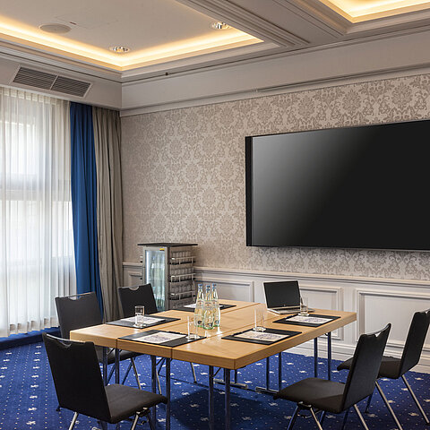 Salle de conférence de l'hôtel Maritim Würzburg avec équipement moderne et grand écran.