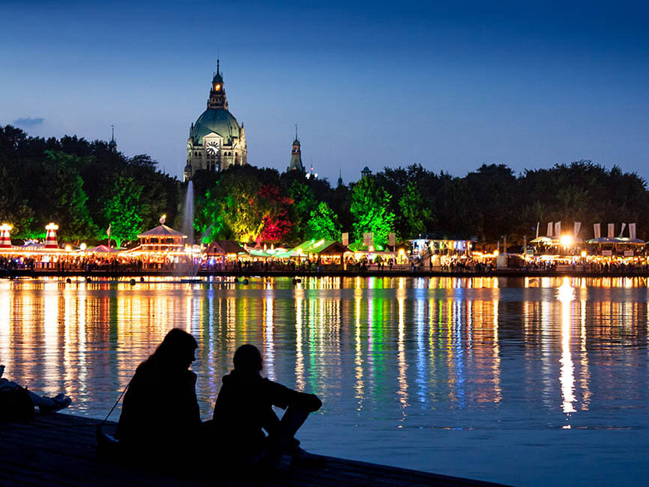 Festa del Maschsee ad Hannover di notte con lungolago illuminato e riflessi sull’acqua