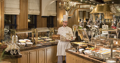 Buffet de petit-déjeuner au restaurant "Rôtisserie" de l'hôtel Maritim Bonn avec une variété de plats et un chef sympathique.