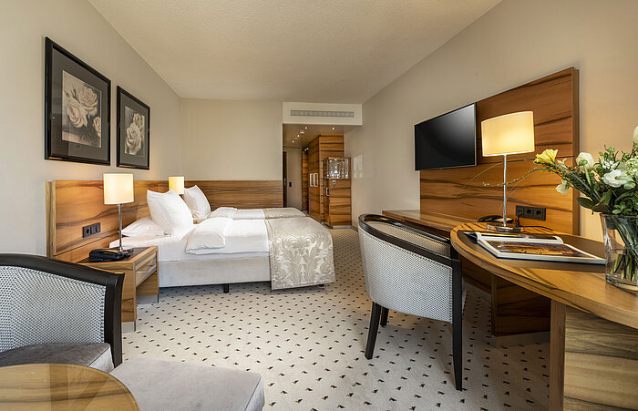 Chambre confort à l'hôtel Maritim Bad Homburg avec lit double, décor en bois élégant et équipements modernes.