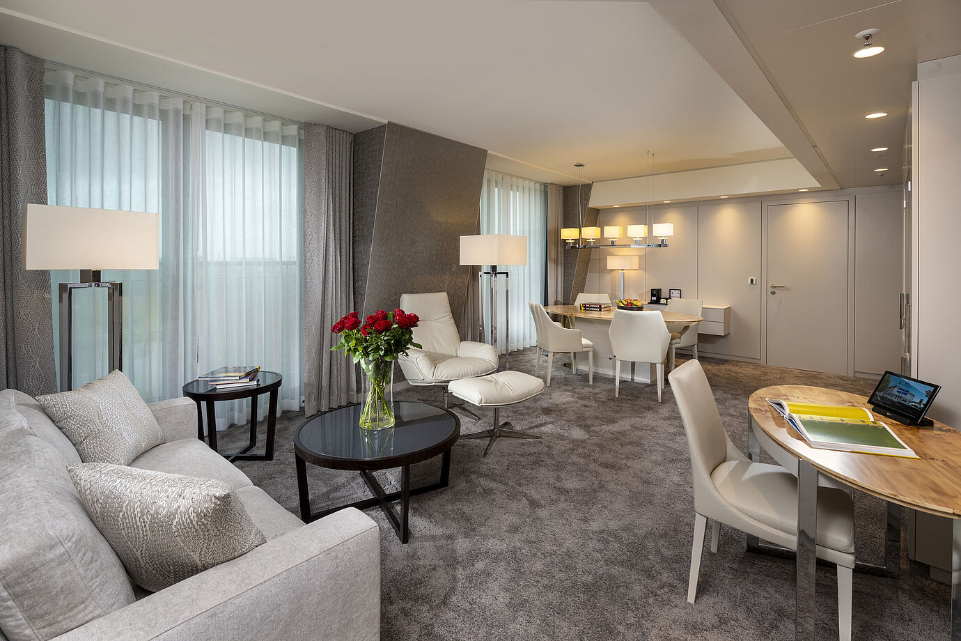 Suite de alta gama con interior elegante, zona de estar, mesa de comedor y decoración sofisticada.