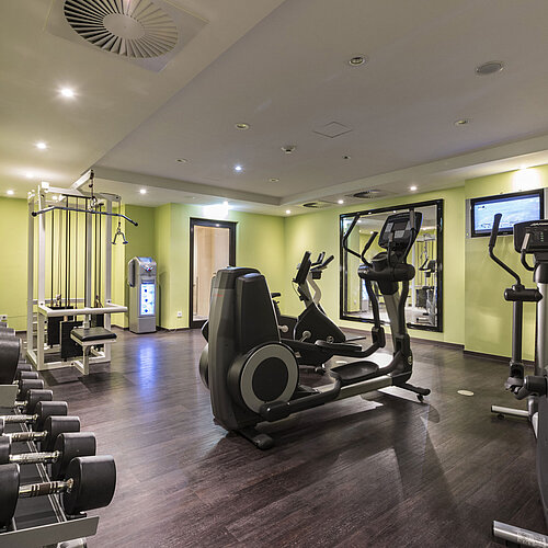 Palestra moderna del Maritim Hotel Königswinter con tapis roulant, pesi e attrezzature.