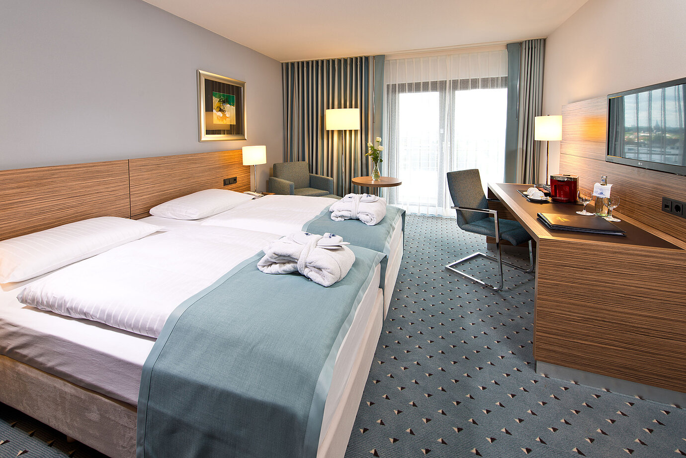 Superior room at Maritim Hotel Darmstadt featuring stylish design, desk, cozy seating area, and double bed with bathrobes.