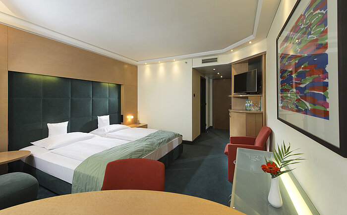 Chambre Confort au Maritim proArte Hotel Berlin, avec mobilier moderne, lit double, œuvre d'art et bureau.