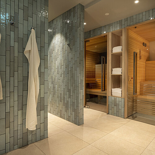 Area sauna moderna con asciugamani e accappatoi al Maritim Hotel Monaco