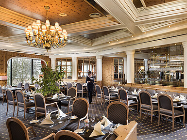 Restaurante rústico de estilo campestre con mesas puestas en el Maritim Hotel Ulm