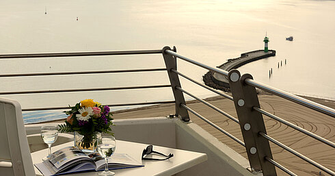 Balcone con vista mare al Maritim Hotel Travemünde, tavolo con vino e fiori