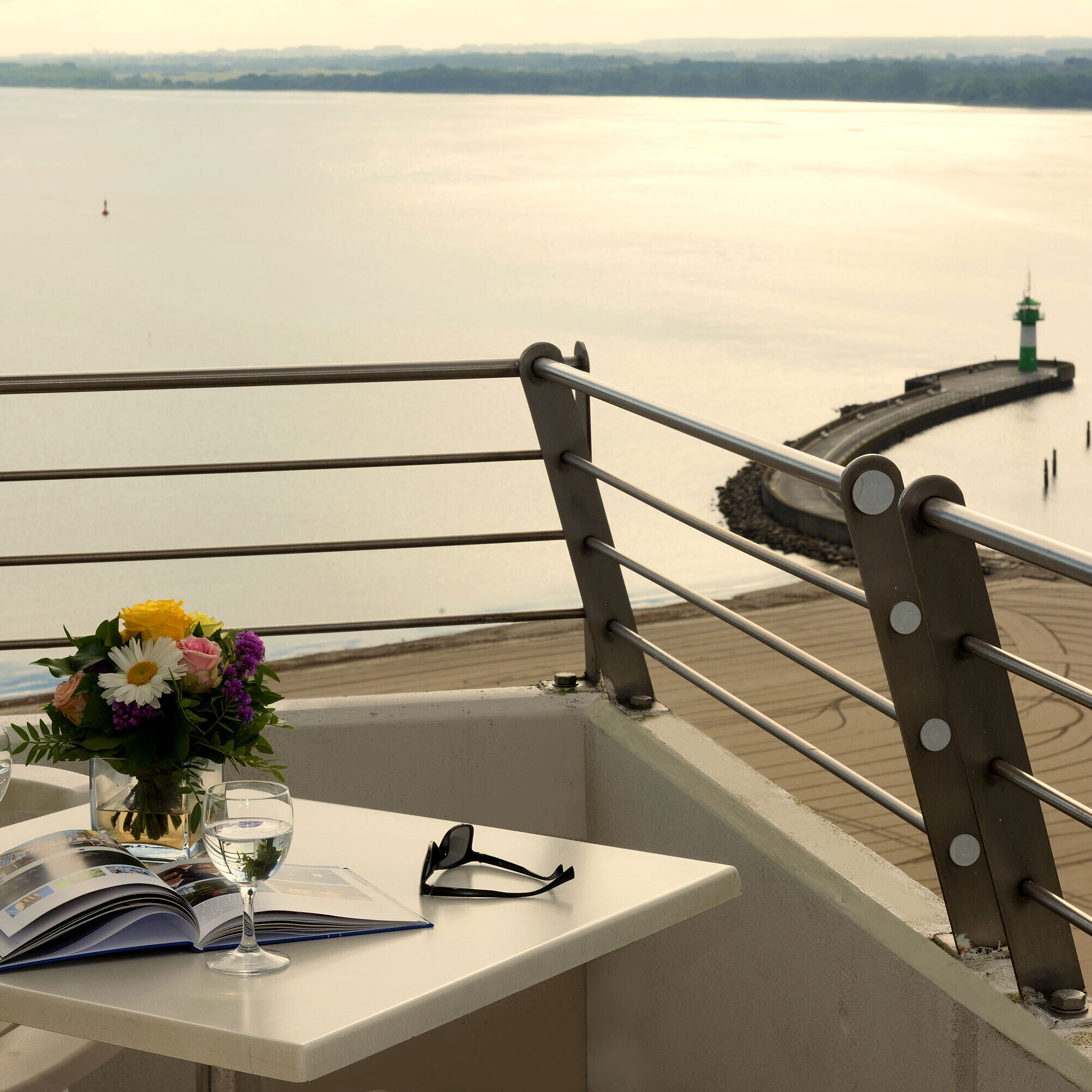 Balcony of suite with sea view Balcony with sea view at Maritim Hotel Travemünde, table set with wine and flowers