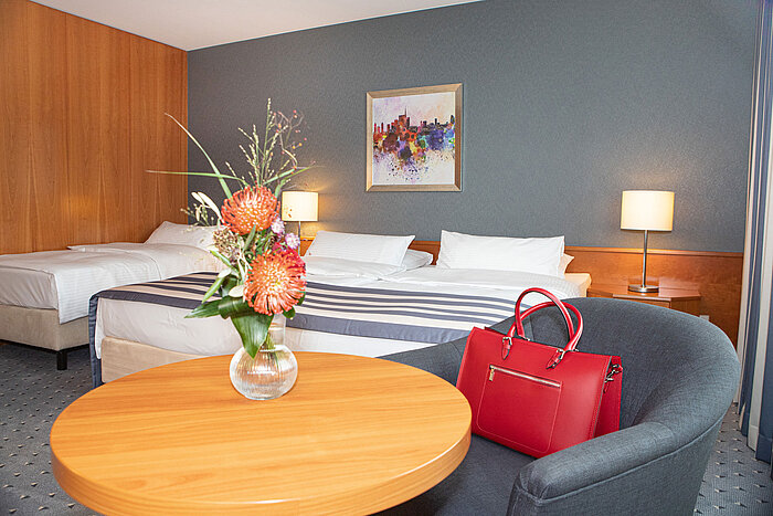 Ampia camera familiare al Maritim Hotel Ulm con servizi moderni e scrivania.