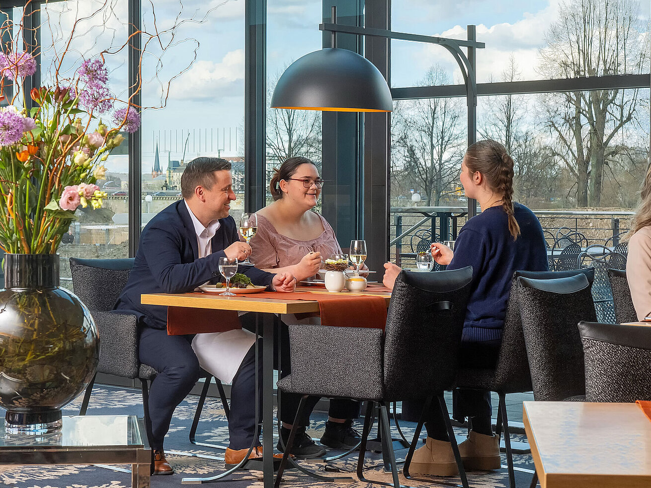 Wintergarten Restaurant Guests enjoying a meal in the restaurant at Maritim Hotel Dresden with outdoor views.