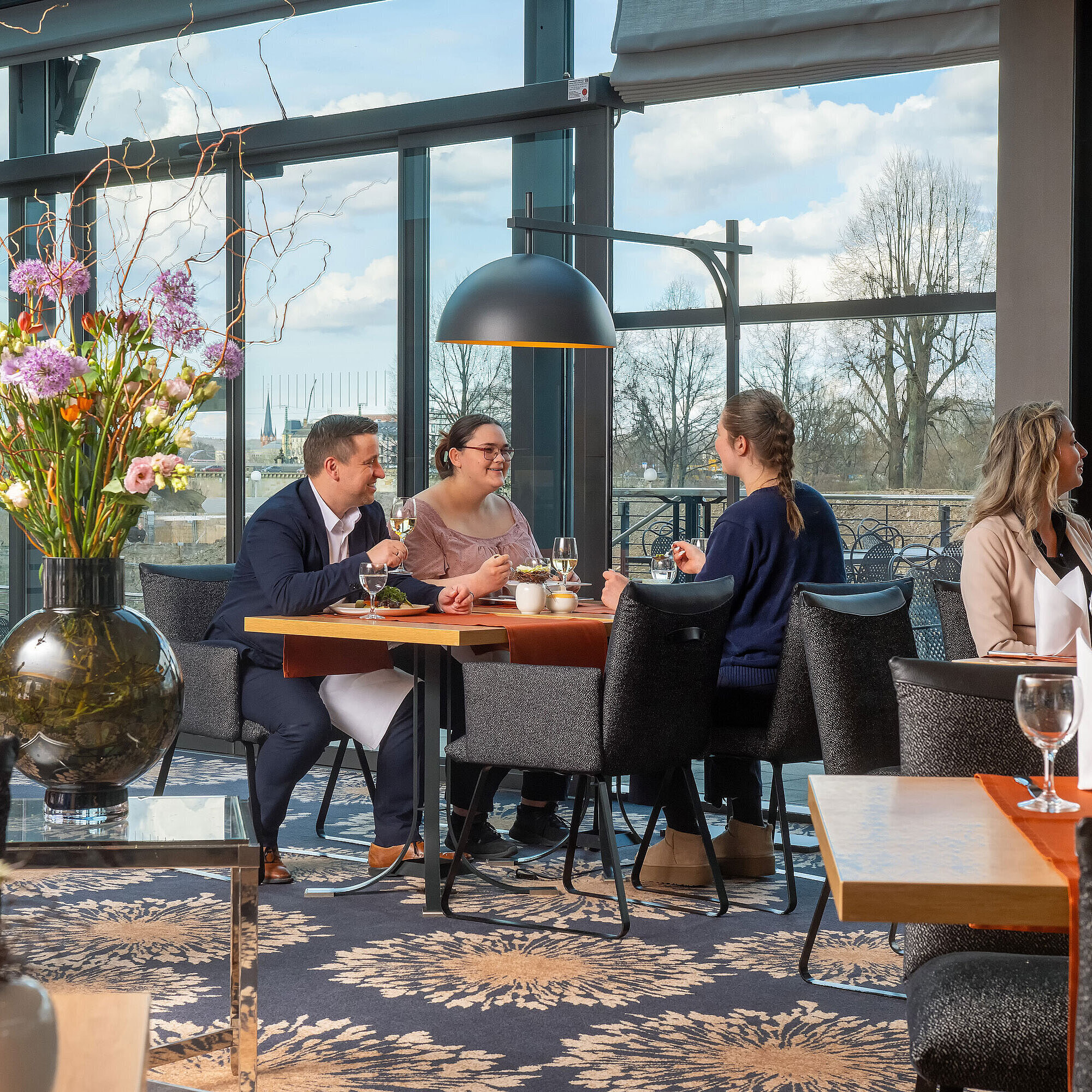 Guests enjoying a meal in the restaurant at Maritim Hotel Dresden with outdoor views.