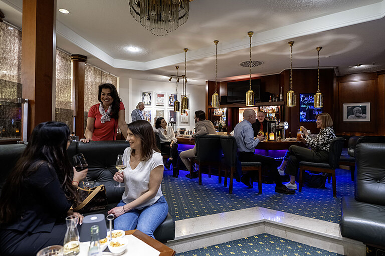 Guests enjoy drinks in the stylish bar of Maritim Hotel Bad Homburg with a relaxed atmosphere and warm ambiance.