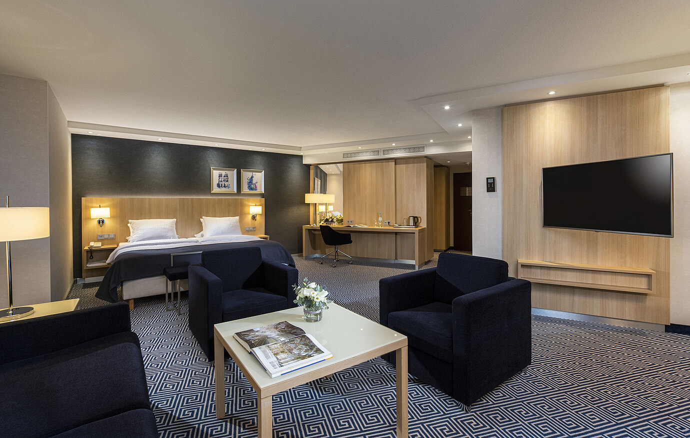 Ampia Junior Suite del Maritim Hotel Würzburg con letto matrimoniale e area salotto accogliente
