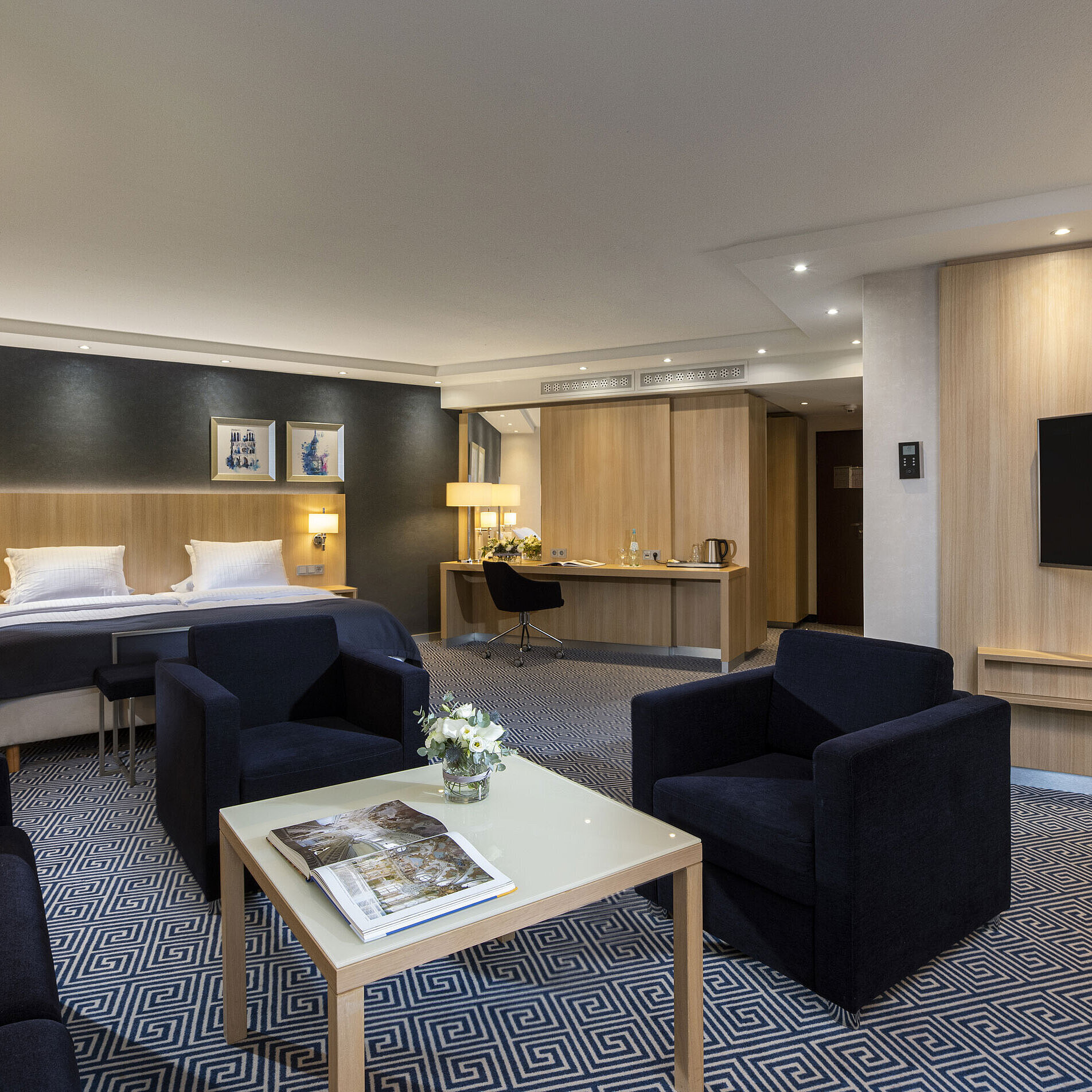Suite Junior Ampia Junior Suite del Maritim Hotel Würzburg con letto matrimoniale e area salotto accogliente