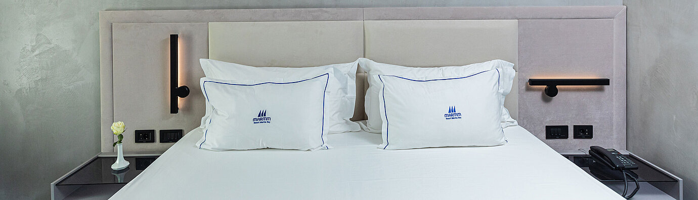 Cama doble moderna en el Maritim Resort Marina Bay con cabecero elegante y cojines