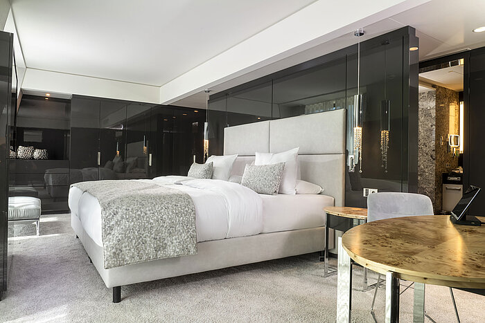 Habitación elegante del Maritim Hotel Ingolstadt con cama king-size, detalles modernos y luz cálida.
