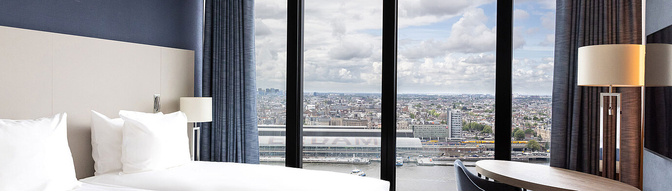 Bedroom with panoramic view Double room with large window and view of Amsterdam at Maritim Hotel