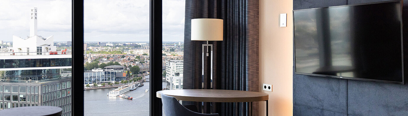 Seating area with table and view over Amsterdam in Maritim Hotel Amsterdam
