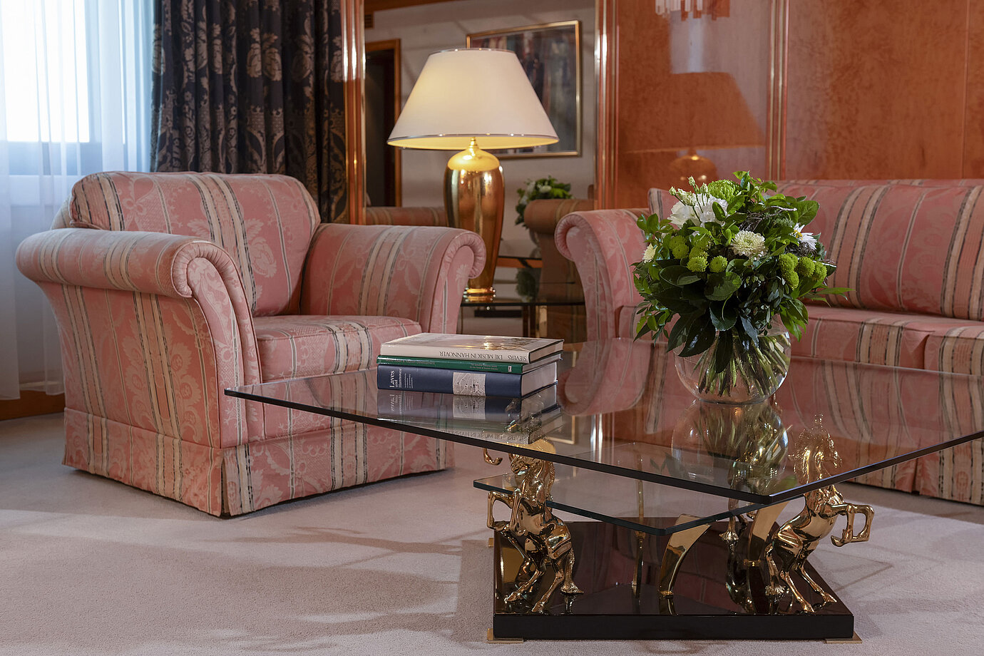 Soggiorno elegante al Maritim Hotel Hannover con area salotto raffinata e tavolino in vetro.