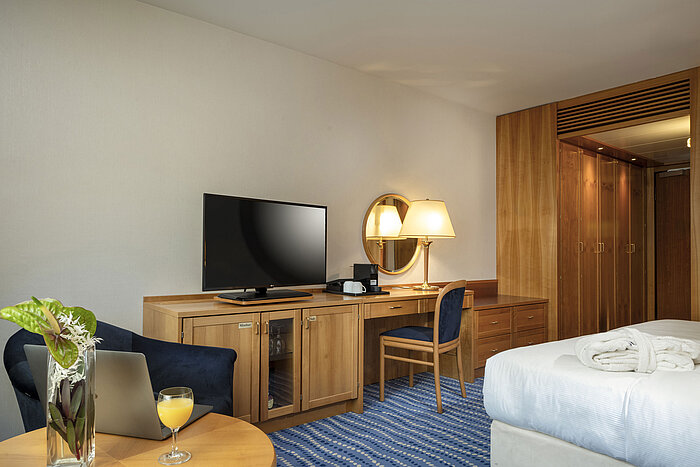 Bureau avec télévision et lampe dans une chambre supérieure avec accents bois et bleus.