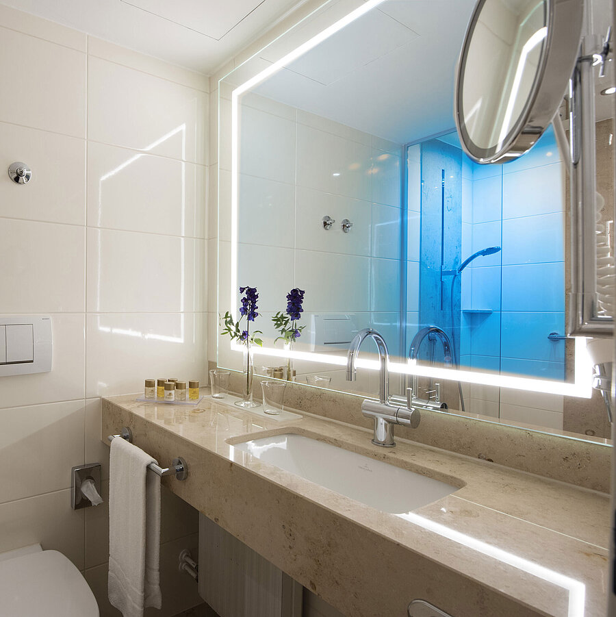  Salle de bain lumineuse avec grand miroir et produits au Maritim Hotel Titisee