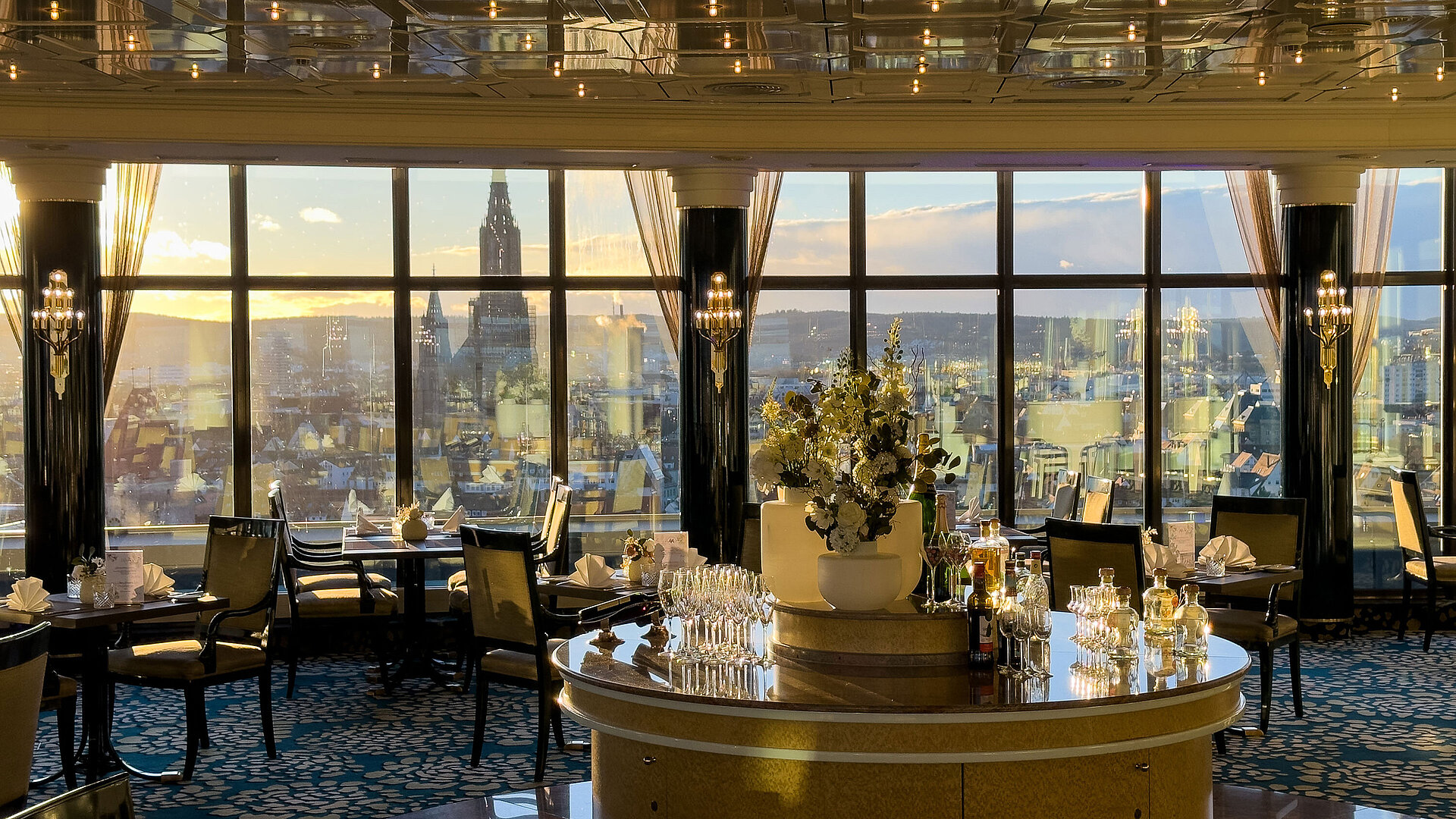 "Das Ulmer" Restaurant Elegant restaurant in Maritim Hotel Ulm with large panoramic windows overlooking the city at sunset