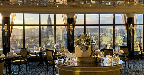 Elegant restaurant in Maritim Hotel Ulm with large panoramic windows overlooking the city at sunset