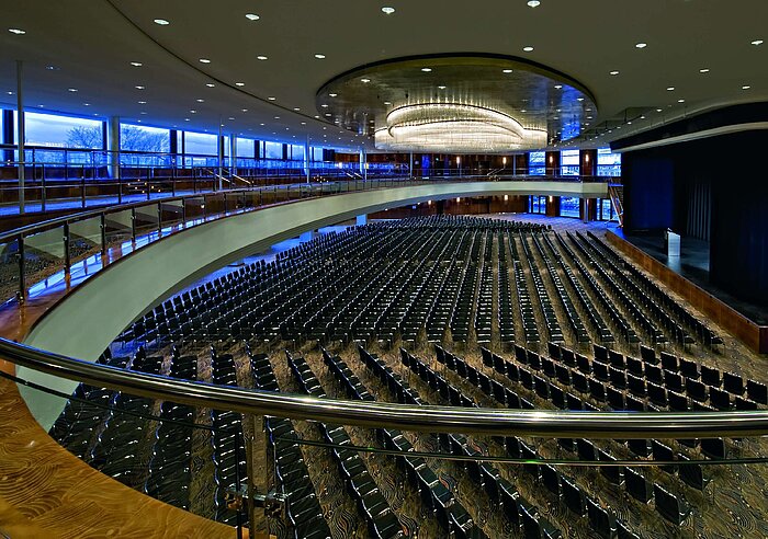 Spacious event hall at Maritim Hotel Düsseldorf with row seating and an elegant gallery for conferences and events.