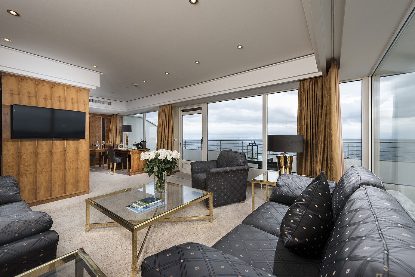  Salon de penthouse avec vue sur la mer, mobilier élégant et grande baie vitrée au Maritim Seehotel Timmendorfer Strand.