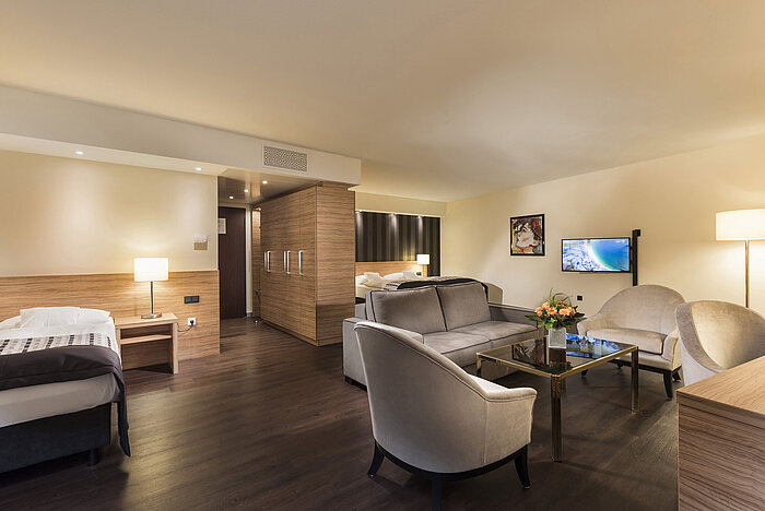 Suite élégante de l'hôtel Maritim Königswinter avec espace salon moderne et mobilier luxueux.
