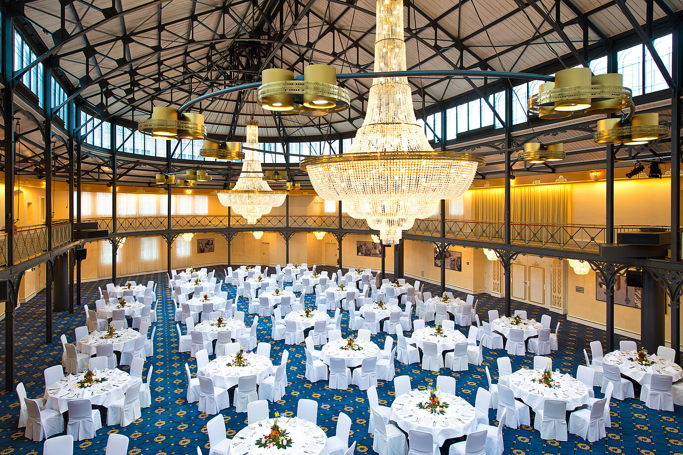 Gran salón con mesas redondas y candelabros en el Maritim Hotel Stuttgart