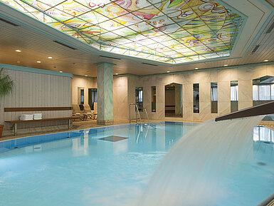 Heated indoor pool with waterfall and colourful glass ceiling at the Maritim Hotel Stuttgart