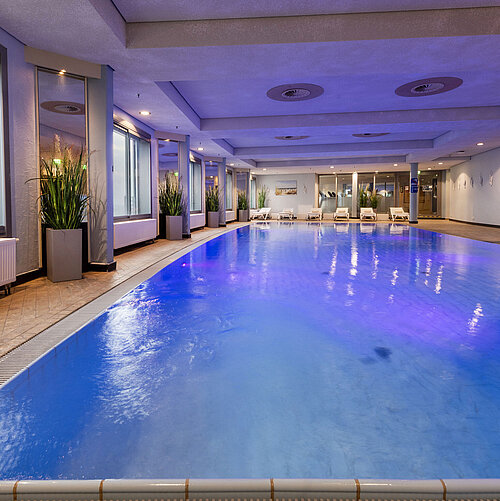 Piscina coperta illuminata del Maritim Hotel Frankfurt con atmosfera rilassante e finestre panoramiche.