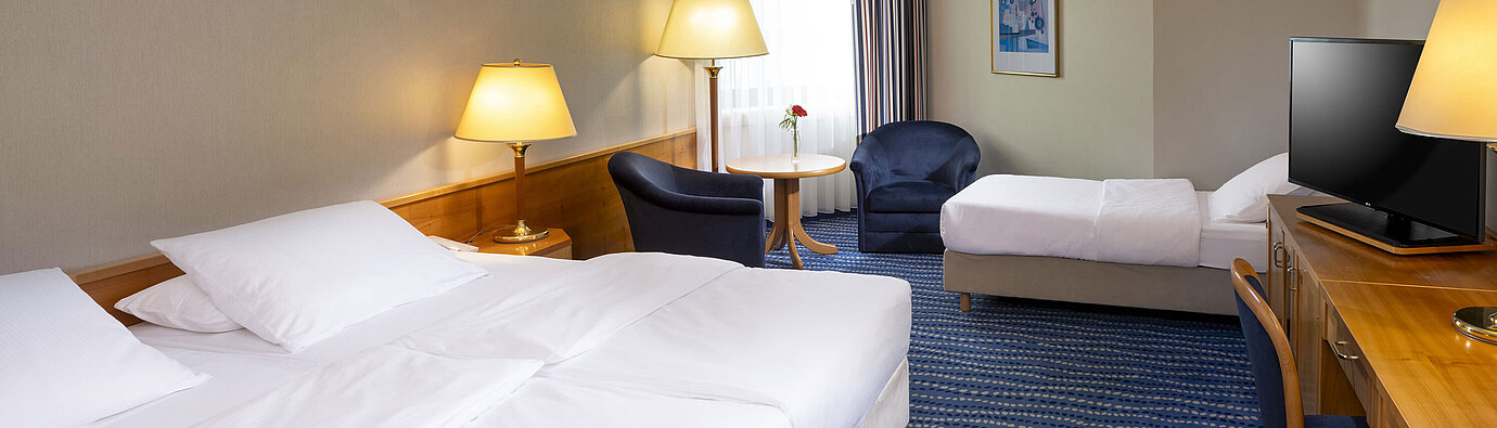 Camera di famiglia Classic Camera familiare classica con due letti, scrivania, TV a schermo piatto.