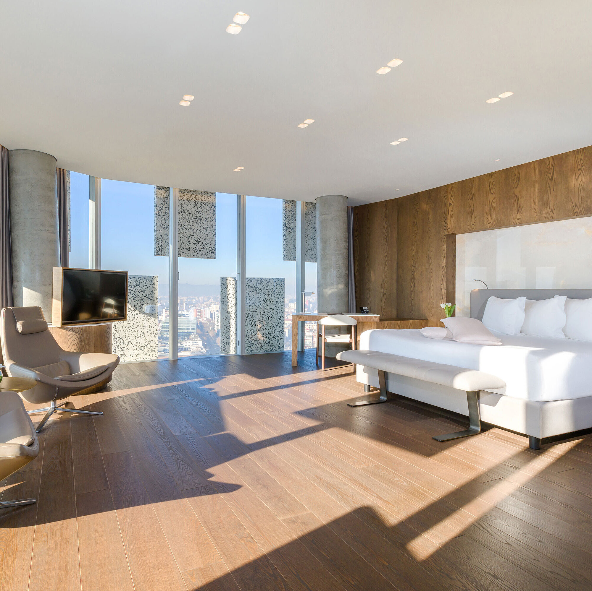 Chambre Suite panoramique lumineuse avec vue sur la ville et mobilier design au Maritim Hotel Plaza Tirana
