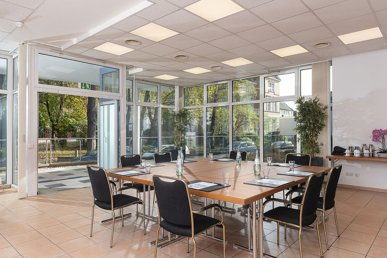 Sala de conferencias con grandes ventanales y acceso directo a la terraza en el Maritim Hotel Königswinter.