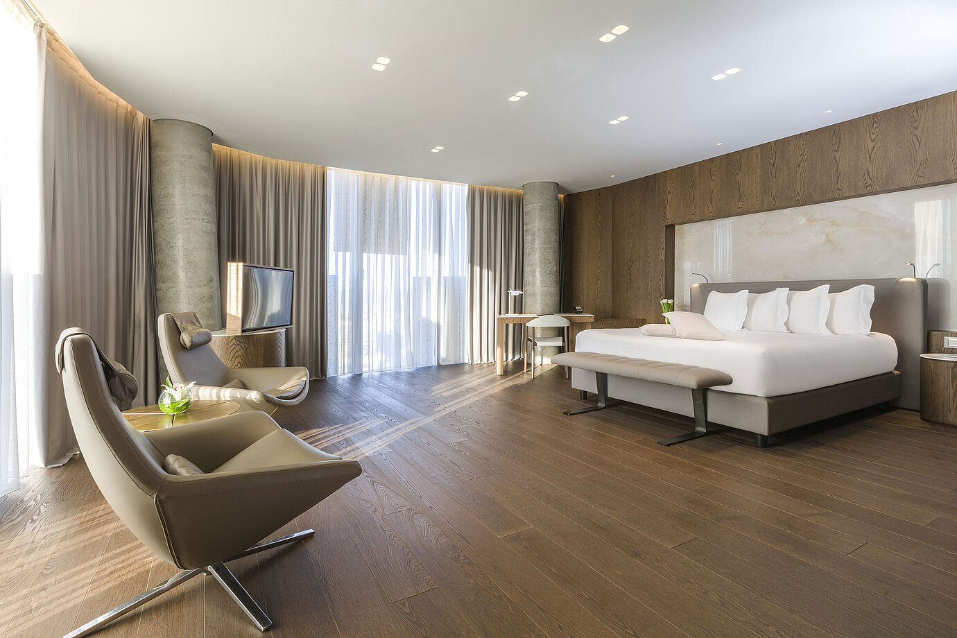 Grande chambre avec fenêtres panoramiques, fauteuils et design moderne au Maritim Hotel Plaza Tirana