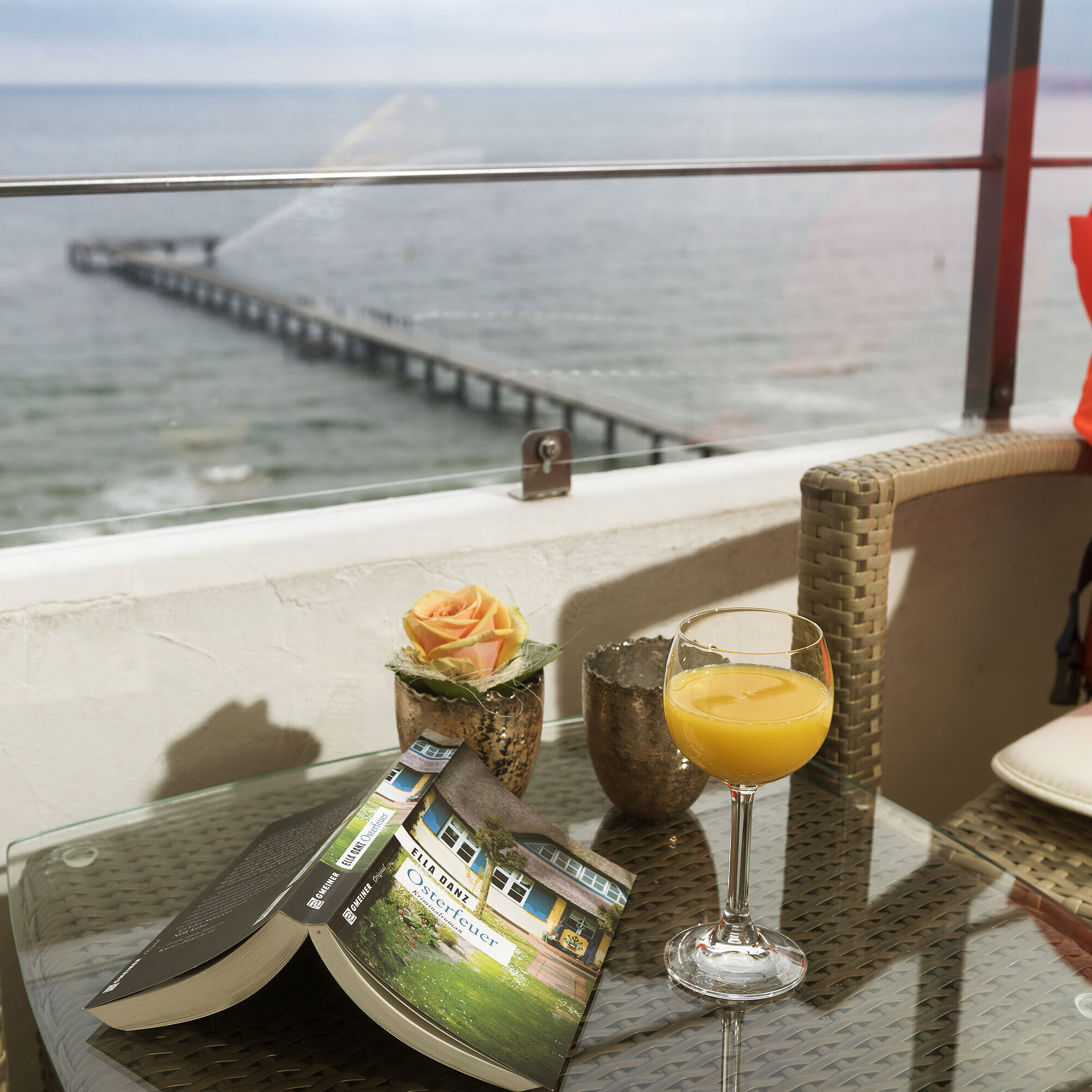 Balcon avec vue sur la mer Balcon avec vue sur la mer, verre de jus d'orange, livre et gilet de sauvetage au Maritim Seehotel Timmendorfer Strand.