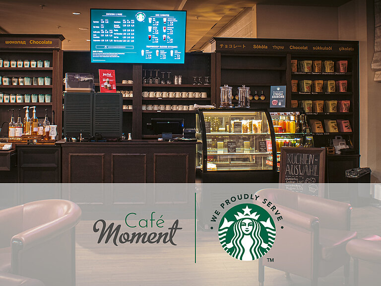 Café del Maritim Hotel Bonn con café Starbucks, mostrador de snacks, vitrina de pasteles y asientos acogedores