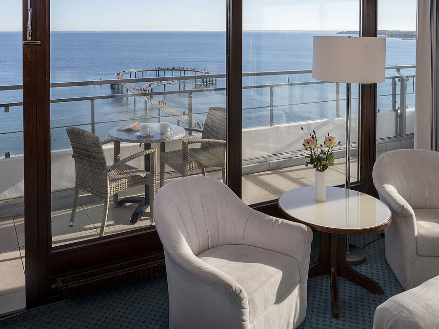 Hotel room with seating area and balcony with sea view at Maritim Seehotel Timmendorfer Strand.