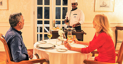 Couple savourant un dîner exclusif avec cuisine en direct à table