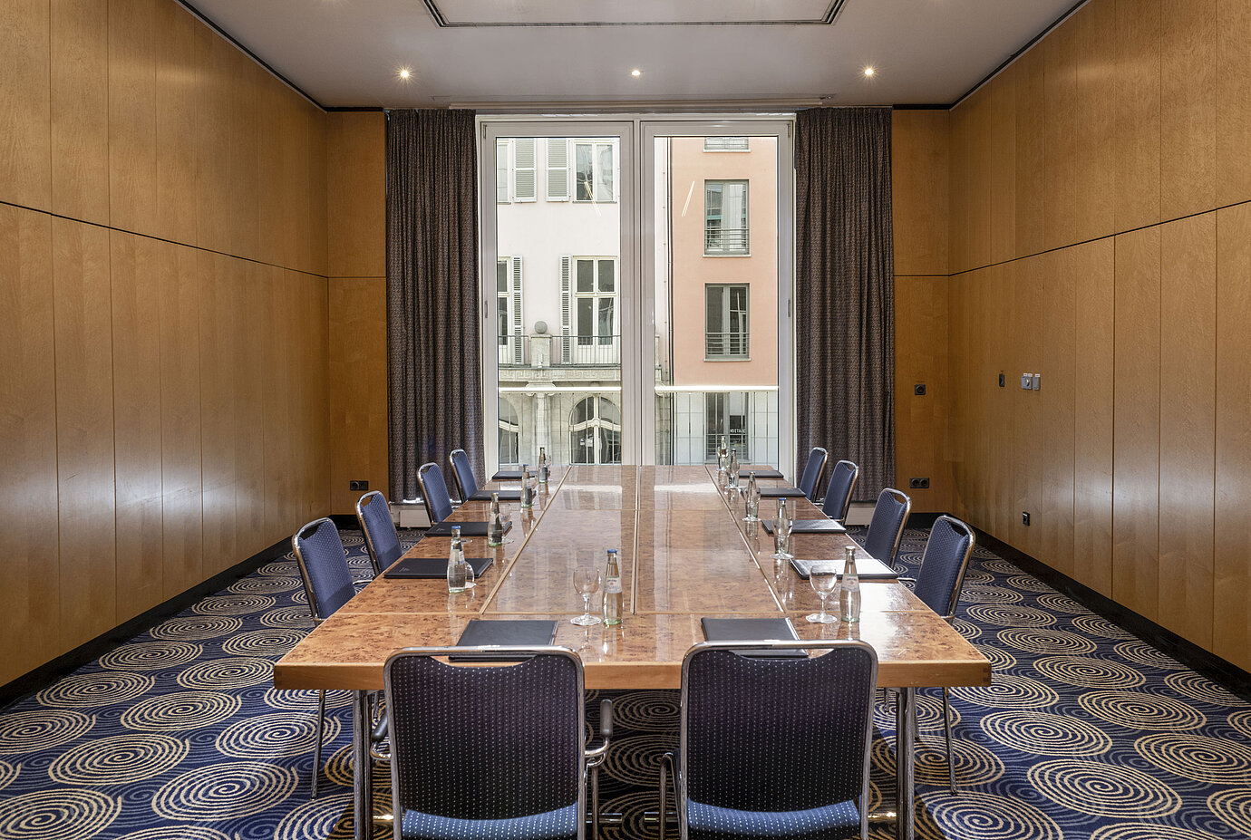 Sala de reuniones luminosa Salón I en el Hotel Maritim proArte Berlín con gran mesa de conferencia y vista exterior.