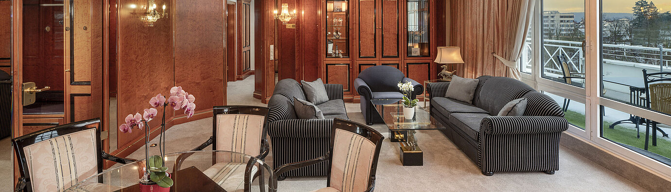 Amplia suite con lámpara de araña, muebles elegantes y vistas al atardecer en el Maritim Hotel Bad Wildungen