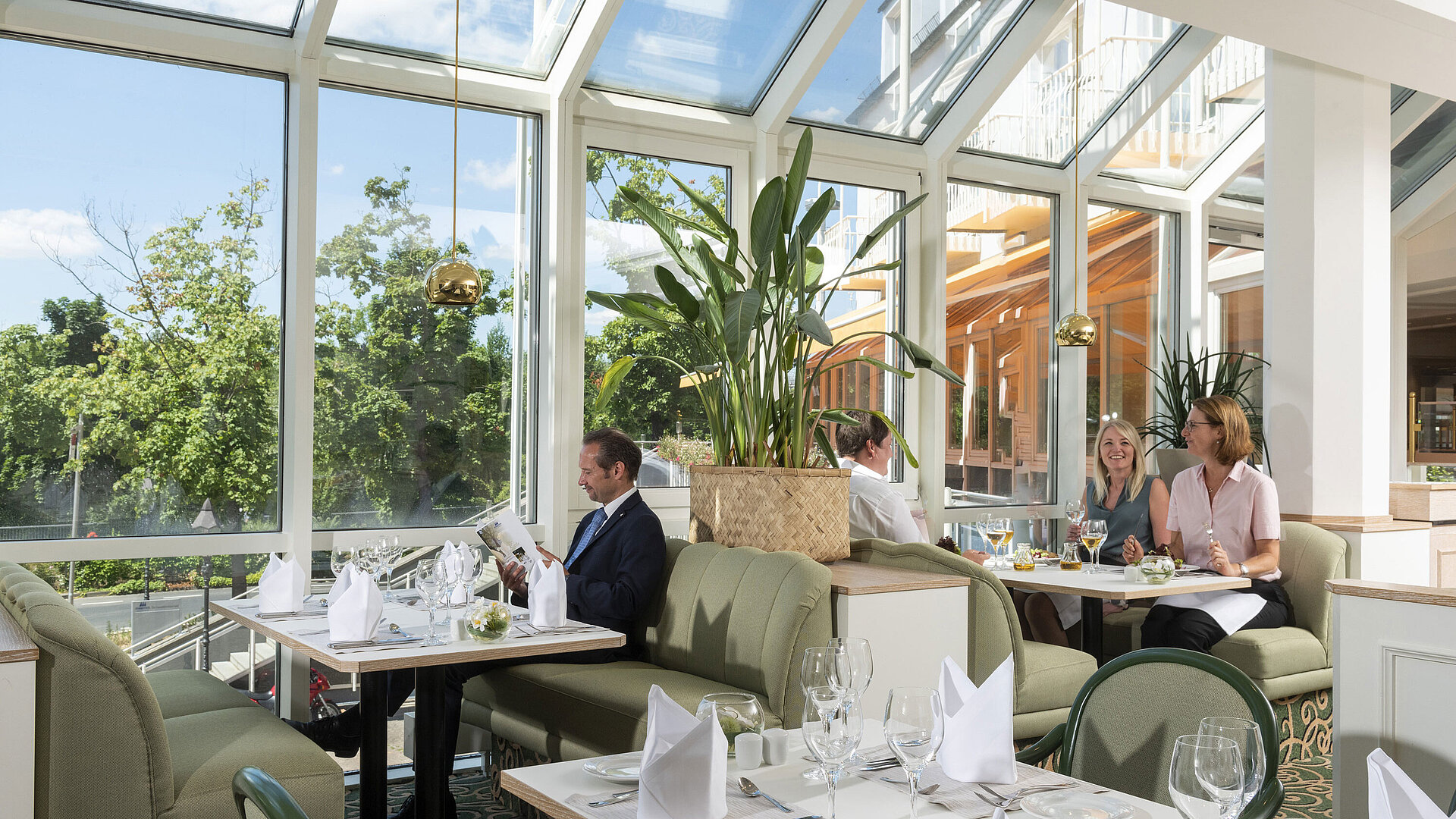 Spacious restaurant at Maritim Hotel Würzburg with panoramic windows and an inviting seating area