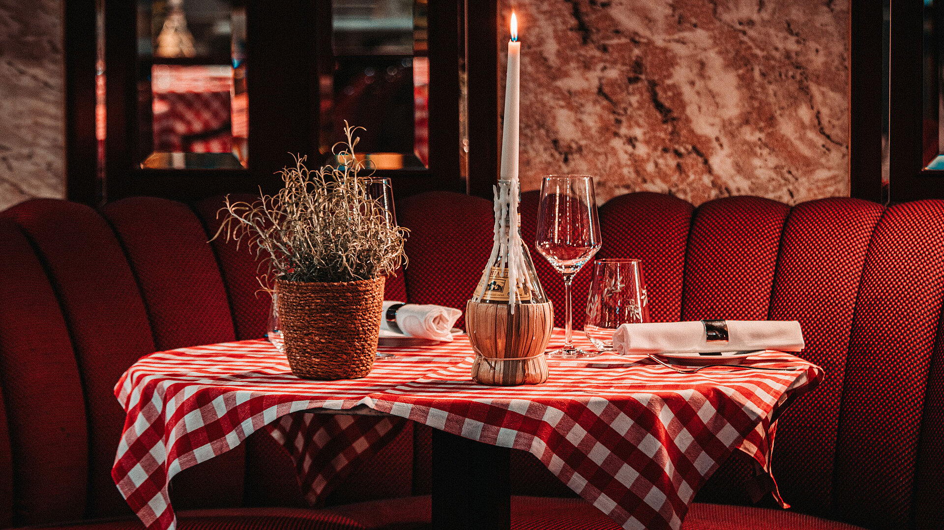 Romantic table setting with candle and checkered tablecloth in restaurant