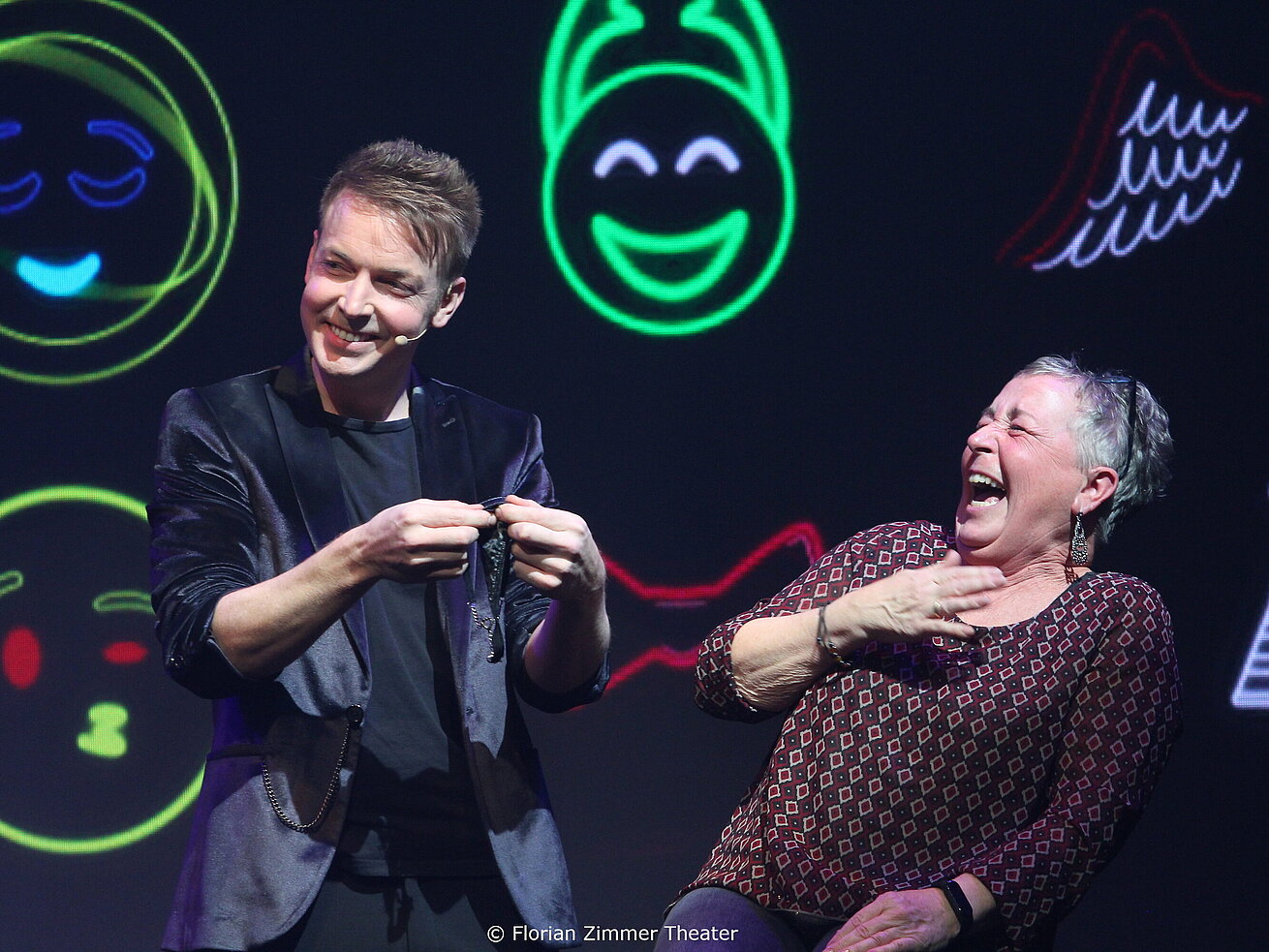 Magicien Florian Zimmer sur scène au théâtre d’Ulm avec effets lumineux.