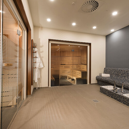Area sauna rilassante del Maritim Hotel Bonn con seduta moderna e vasca Kneipp per recupero e benessere.